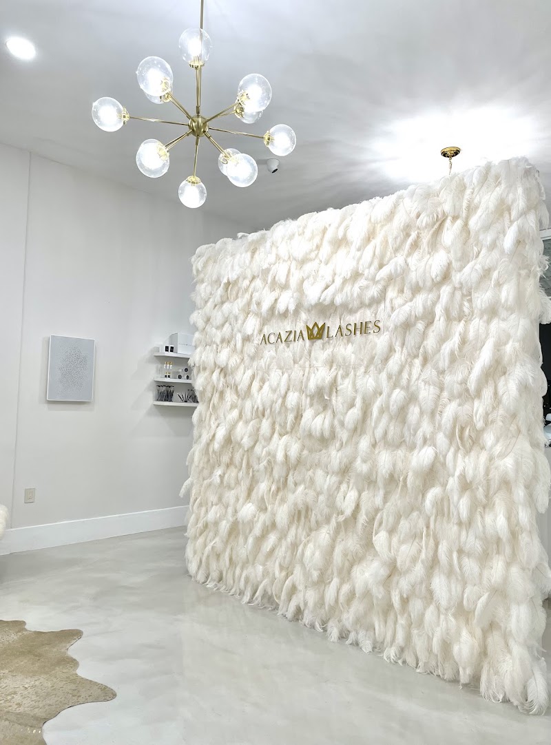 Interior del salón Acazia Lashes con pared de plumas